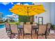 Outdoor patio with dining table and seating under a yellow umbrella at 1023 Tocobaga Ln, Sarasota, FL 34236