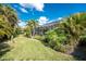 Green lawn, tropical plants, and a screened-in lanai create a relaxing outdoor space at 1069 Harbour Cape Pl, Punta Gorda, FL 33983