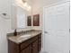 Bathroom with granite countertops, vanity, framed mirror and dark wood cabinets at 1069 Harbour Cape Pl, Punta Gorda, FL 33983