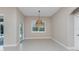 Dining area with an elegant woven pendant light, sliding doors, and neutral paint at 1069 Harbour Cape Pl, Punta Gorda, FL 33983