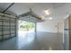 Well-lit garage with epoxy flooring, an open door, and a refrigerator, ready for all your storage needs at 1069 Harbour Cape Pl, Punta Gorda, FL 33983