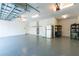 Organized garage with epoxy floor, refrigerator, shelving, and a door for easy access to the house at 1069 Harbour Cape Pl, Punta Gorda, FL 33983