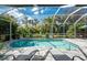 Relaxing screened pool area with sun loungers, lush landscaping, and clear blue water at 1069 Harbour Cape Pl, Punta Gorda, FL 33983