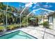 Screened pool area with outdoor dining and lush tropical surroundings at 1069 Harbour Cape Pl, Punta Gorda, FL 33983