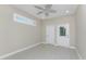 An empty, bright room with tile flooring, ceiling fan and two entry doors at 1069 Harbour Cape Pl, Punta Gorda, FL 33983