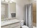 Bathroom with granite countertop, shower, and gray patterned curtain at 11101 Sandhill Preserve Dr, Sarasota, FL 34238