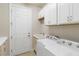 Bright laundry room with washer, dryer, and ample cabinet space at 11101 Sandhill Preserve Dr, Sarasota, FL 34238