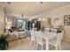 Bright dining room with white table and chairs, adjacent to living room at 114 Babbling Brook Run, Bradenton, FL 34212