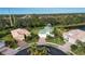 Aerial view of houses with a pond and green space in the background at 11458 Saffron Ct, Venice, FL 34292