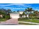 Tan house with green roof and palm trees in the front yard at 11458 Saffron Ct, Venice, FL 34292