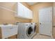 Laundry room with washer, dryer, cabinets, and utility sink at 11458 Saffron Ct, Venice, FL 34292