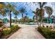 Brick walkway leads to a refreshing pool area with numerous palm trees at 11458 Saffron Ct, Venice, FL 34292