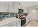 Modern kitchen with gray cabinets, quartz countertops and a mosaic backsplash at 12977 Twin Bridges Dr, Riverview, FL 33579