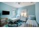 Two twin beds, a dresser and a wall-mounted TV in a light blue room at 13299 Rinella St, Venice, FL 34293