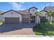 Two-story home with two-car garage, paver driveway, and landscaping at 13299 Rinella St, Venice, FL 34293