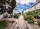 Brick pathway leads through lush landscaping between buildings at 1336 Benjamin Franklin Dr # 1F, Sarasota, FL 34236