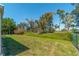 Landscaped backyard with a grassy area and mature trees at 134 Rotonda Cir, Rotonda West, FL 33947