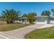 Ranch-style home with a white garage door and palm trees at 134 Rotonda Cir, Rotonda West, FL 33947