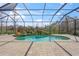 Private screened pool featuring lovely tropical landscaping and a rock waterfall feature at 14208 Woodhall Pl, Bradenton, FL 34202