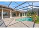 This backyard features a private screened pool surrounded by tropical landscaping at 14208 Woodhall Pl, Bradenton, FL 34202