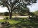 Landscaped front yard with a large tree and bird bath at 15079 Wichita Rd, Port Charlotte, FL 33981