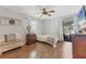 Cozy bedroom with wood floors, ceiling fan, bench, and sliding glass doors to the outdoor area at 1573 Shadow Ridge Cir, Sarasota, FL 34240