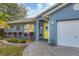 Front entrance with yellow door, landscaping, and paver walkway at 2207 22Nd W St, Bradenton, FL 34205