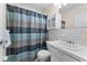 Bathroom with shower/tub, vanity, and plaid shower curtain at 2459 Franciscan Dr # 5, Clearwater, FL 33763