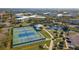 Aerial view of tennis and pickleball courts near a pond at 2459 Franciscan Dr # 5, Clearwater, FL 33763