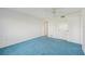 Bright bedroom with blue carpet, ceiling fan, and ample closet space at 250 Santa Maria St # 120, Venice, FL 34285