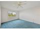 Bedroom with blue carpet, window, and ceiling fan offering natural light at 250 Santa Maria St # 120, Venice, FL 34285