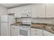 Updated kitchen featuring granite countertops and white cabinets at 250 Santa Maria St # 120, Venice, FL 34285