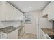 White kitchen with granite counters and built-in workspace at 250 Santa Maria St # 120, Venice, FL 34285