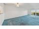 Bright living room with blue carpet and sliding glass doors at 250 Santa Maria St # 120, Venice, FL 34285