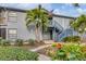 Gray condo building with stairs, landscaping, and palm trees at 2728 71St Street W Ct # 2078, Bradenton, FL 34209