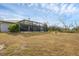 Open backyard featuring a well-maintained lawn extending beyond the screened pool area at 2926 Sultan Ct, North Port, FL 34286