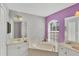 Bright bathroom with a soaking tub, white cabinets, and calming purple walls at 2926 Sultan Ct, North Port, FL 34286