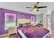 Cozy bedroom with hardwood floors, a ceiling fan, and calming purple walls at 2926 Sultan Ct, North Port, FL 34286