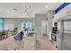 Well-lit kitchen with island, stainless steel refrigerator, and seamless flow into the living area at 2926 Sultan Ct, North Port, FL 34286