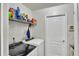 Well-lit laundry room with modern washer and dryer, storage shelves, and utility door at 2926 Sultan Ct, North Port, FL 34286