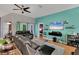 Inviting living room featuring a large TV, floating shelves, light wood flooring, and stylish decor at 2926 Sultan Ct, North Port, FL 34286