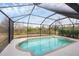 Screened pool with a tiled trim and clear blue water creates a beautiful, relaxing backyard oasis at 2926 Sultan Ct, North Port, FL 34286