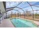 Inviting screened-in pool area surrounded by a screen, lush greenery and blue sky at 2926 Sultan Ct, North Port, FL 34286