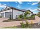 Landscaped walkway leading to a two-car garage with grey doors and lush landscaping at 3016 Formia Ct, Bradenton, FL 34211