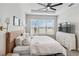 Main bedroom with a king-size bed, large window with blinds, and wall-mounted sconces at 3016 Formia Ct, Bradenton, FL 34211