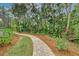 Curved brick pathway meanders through a beautifully landscaped backyard at 3142 Dick Wilson Dr, Sarasota, FL 34240