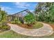 Brick pathway leads to a screened-in patio and lush backyard oasis at 3142 Dick Wilson Dr, Sarasota, FL 34240