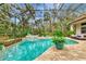 Inviting screened pool and spa with lush landscaping and seating area at 3142 Dick Wilson Dr, Sarasota, FL 34240