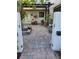 A paved courtyard with potted plants and a pergola at 3455 Anglin Dr, Sarasota, FL 34242