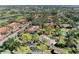 An aerial view of many condos with red roofs nestled among lush trees, with a golf course in the distance at 3500 El Conquistador Pkwy # 119, Bradenton, FL 34210